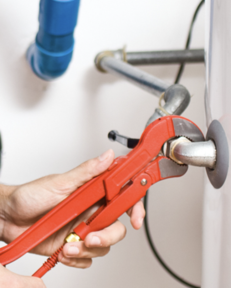 Plumber using a pipe wrench to tighten a fitting