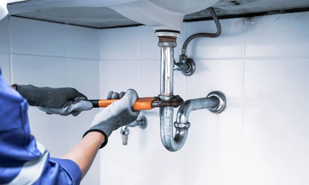 Plumber repairing a sink P-trap and water supply lines
